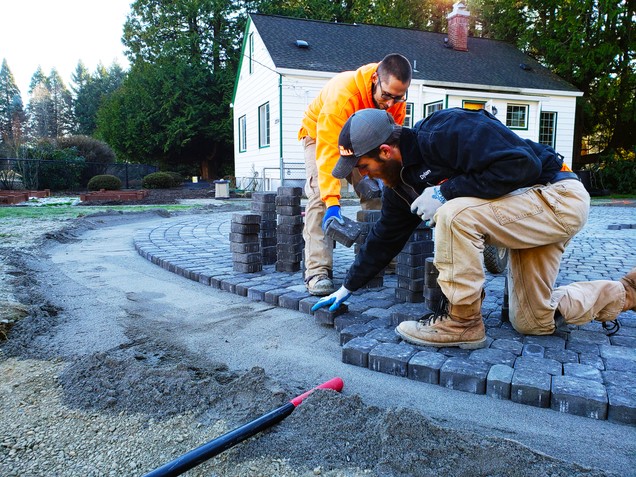 Members of the The Wall construction building a permeable outdoor meeting space