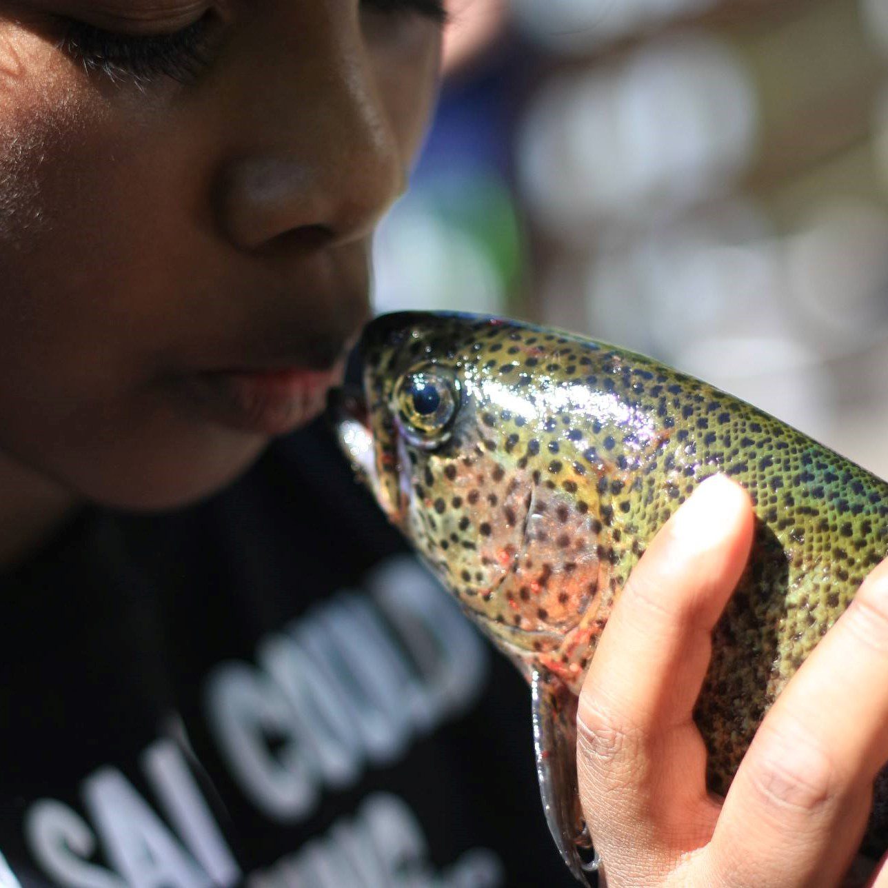 Child kissing a fish