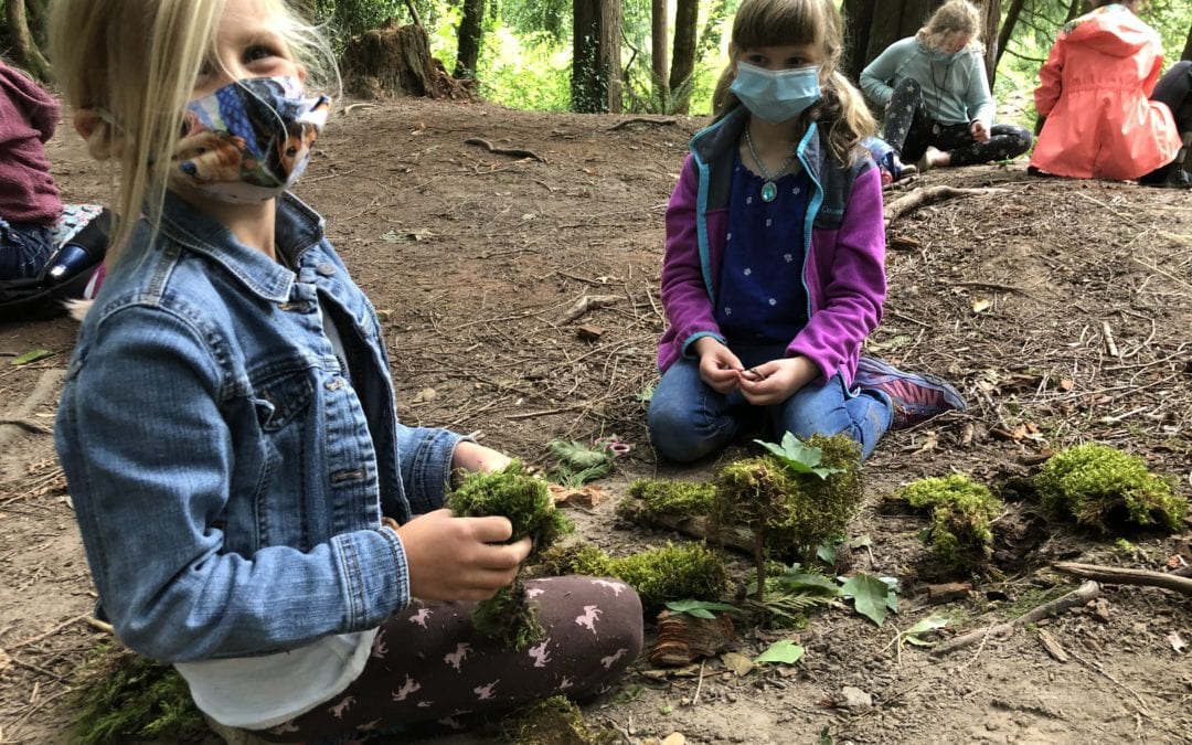 Kids wearing masks and playing with moss